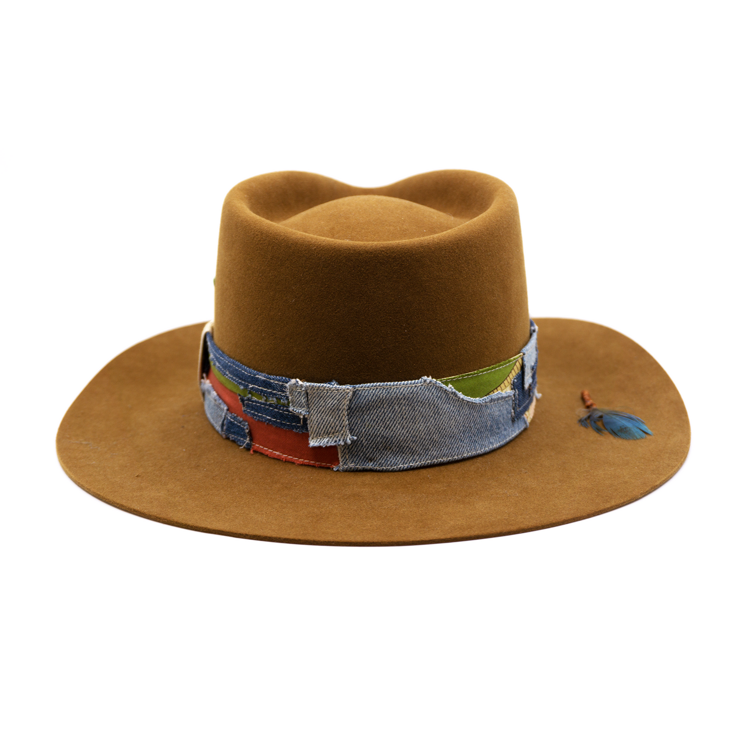 100% felt hat in Baby Suede Dress Weight 1 1/2” Denim and silk patchwork band made with grosgrain crossbow Pinched crown Wax-wrapped molt harvest parrot feather Brass swag clip on brim Flanged brim Made in USA