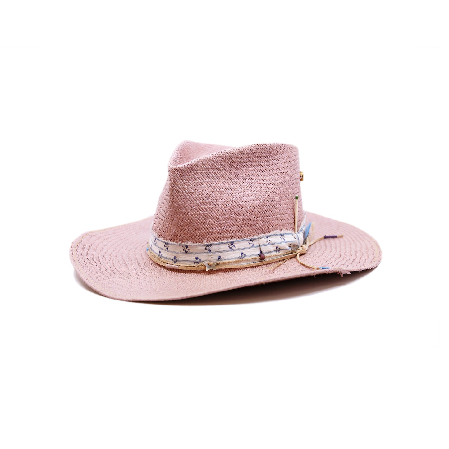 Dandelion Dixie Hwy 100% Ecuadorian straw in Blush 1” deadstock striped fabric band and bow Nude leather band and twine with accouterments and color accents Molt-harvested parrot feather Custom NF jewelry piece on crown Woven in Ecuador Subtle western flanged brim Made in USA