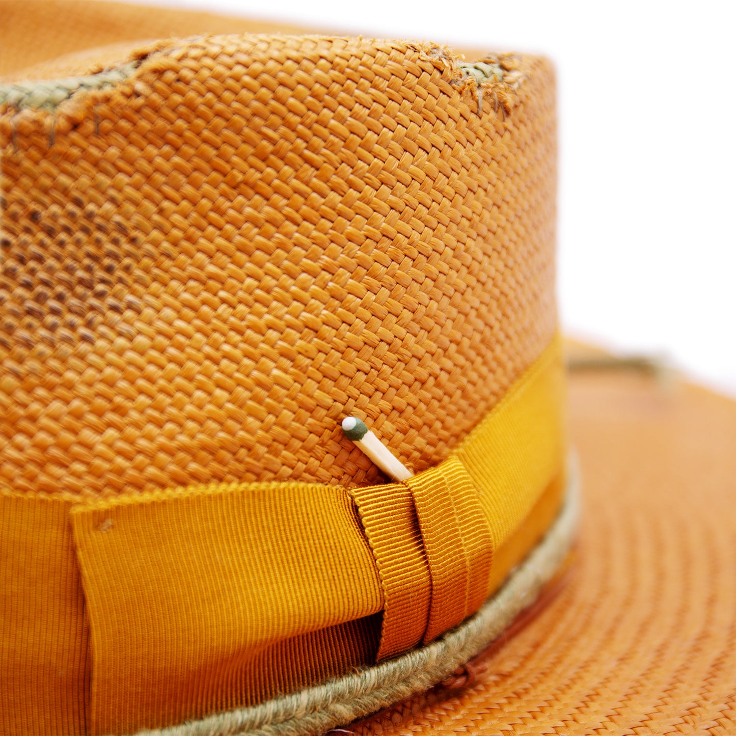 100% Ecuadorian straw hat in Tangerine 2” tonal grosgrain and woven herringbone 2-ply band and bow Distressed and inlay patchwork Woven in Ecuador Wavy brim Made in USA