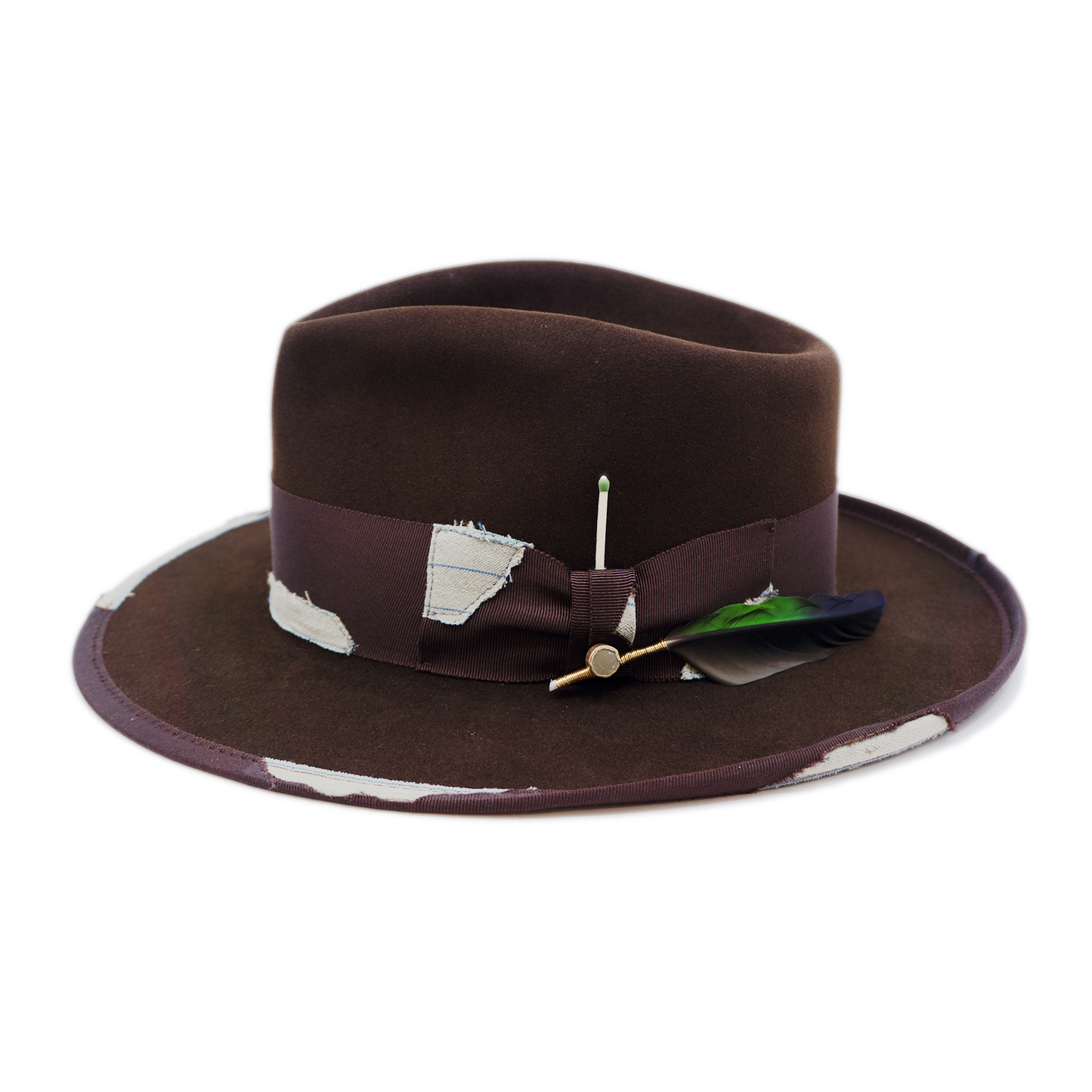 100% felt hat in Grizzly Brown Western Weight 2” tonal grosgrain with NF fabric patchwork Molt-harvested parrot feather with ceramic button Full tonal binding with NF fabric patchwork Pencil curled back brim Made in USA