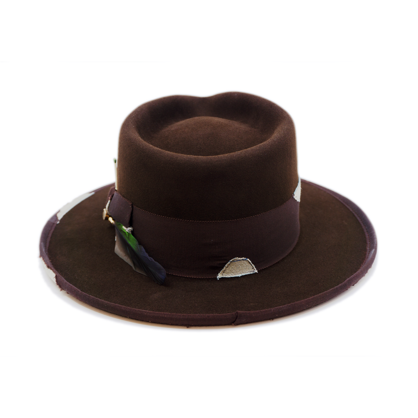 100% felt hat in Grizzly Brown Western Weight 2” tonal grosgrain with NF fabric patchwork Molt-harvested parrot feather with ceramic button Full tonal binding with NF fabric patchwork Pencil curled back brim Made in USA