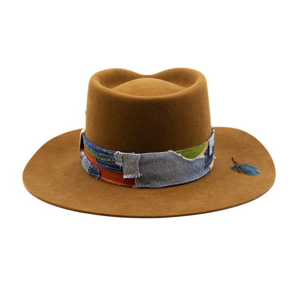 100% felt hat in Baby Suede  Dress Weight   1 1/2” Denim and silk patchwork band made  with grosgrain crossbow  Pinched crown   Wax-wrapped molt harvest parrot feather  Brass swag clip on brim   Flanged brim  Made in USA