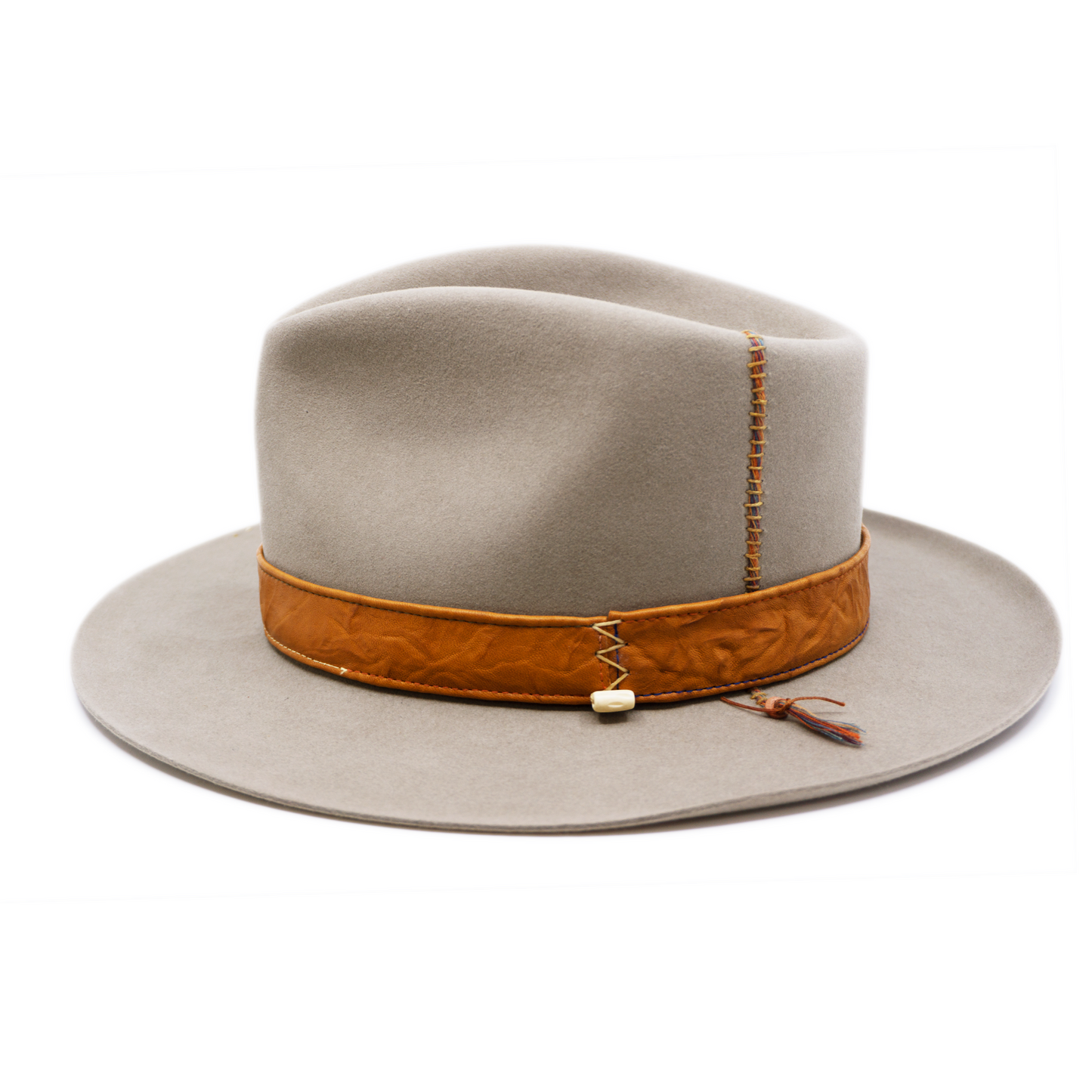 100% felt hat in Naturalll  Dress Weight   1” Caramel borello leather band   Brown tone threads with wax thread edge with cream bone beading  Multicolor hand stitching on crown   Back pencil curled brim  Made in USA 
