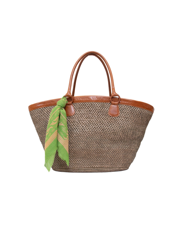 Mer Vert Ecuadorian straw tote bag with brown vachetta leather handles and trim, featuring a green patterned scarf tied to one handle.