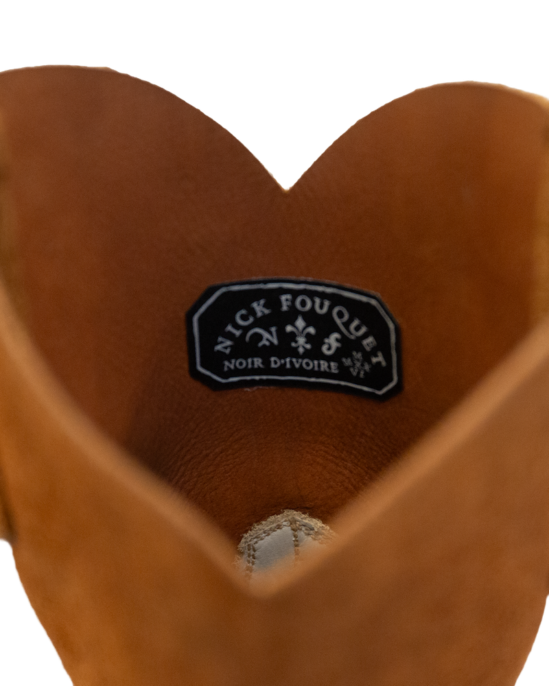 Close-up of the opening of a whiskey brown Silo Roper cowboy boot, showing a black brand label stitched to the inside of the rough-out hide.
