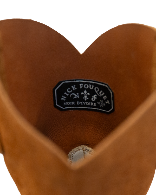 Close-up of the opening of a whiskey brown Silo Roper cowboy boot, showing a black brand label stitched to the inside of the rough-out hide.