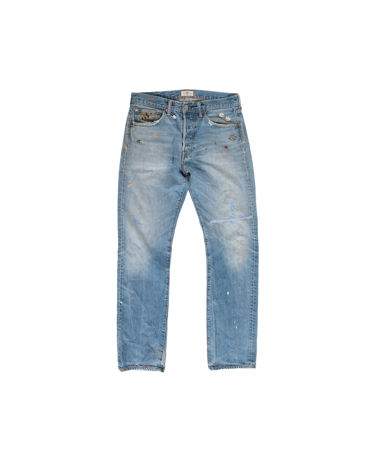 Venice-Store Cote Savauge Denim light-wash, USA-made jeans with a button fly, distressed details, and scattered hand-embroidered patches near the waistband.