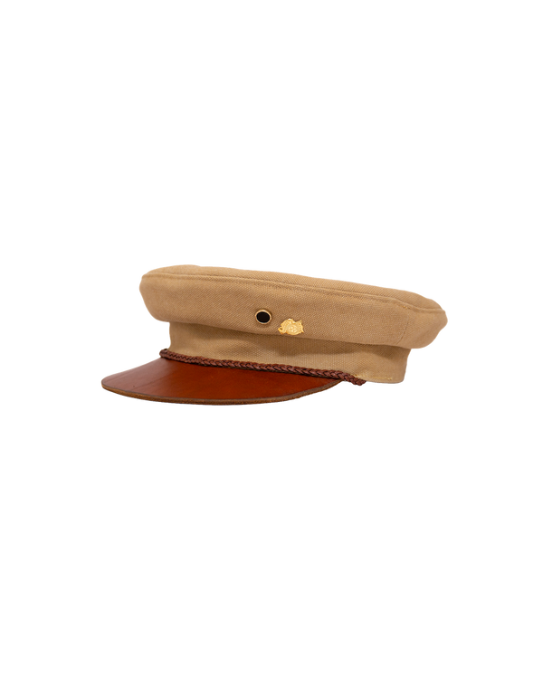 Alcyon captain’s hat in tan canvas with a vachetta leather brim and a braided cord trim.