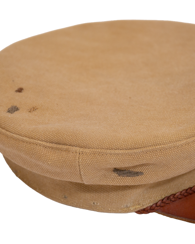 Alcyon sailor cap in tan canvas with a vachetta brim, featuring dark spots on the top and side.