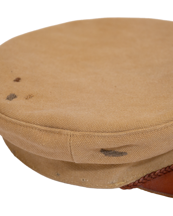 Alcyon sailor cap in tan canvas with a vachetta brim, featuring dark spots on the top and side.