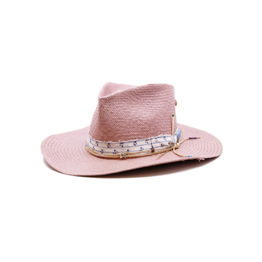 Dandelion Dixie Hwy  100% Ecuadorian straw in Blush  1” deadstock striped fabric band and bow  Nude leather band and twine with accouterments and color accents  Molt-harvested parrot feather  Custom NF jewelry piece on crown  Woven in Ecuador  Subtle western flanged brim  Made in USA