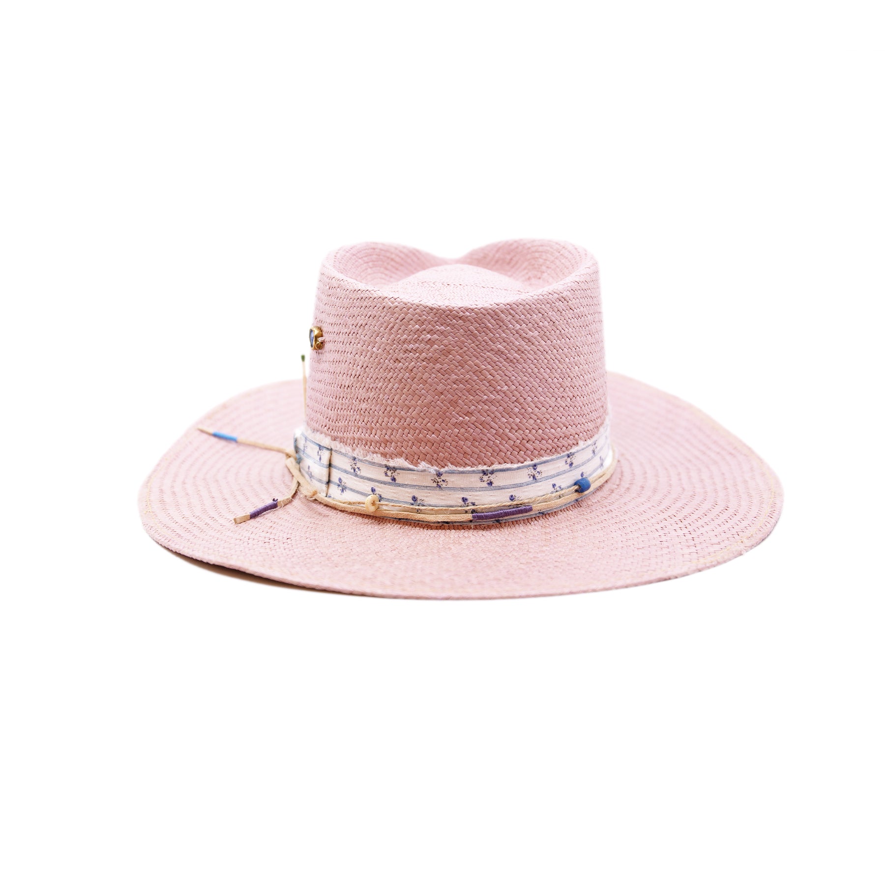 Dandelion Dixie Hwy  100% Ecuadorian straw in Blush  1” deadstock striped fabric band and bow  Nude leather band and twine with accouterments and color accents  Molt-harvested parrot feather  Custom NF jewelry piece on crown  Woven in Ecuador  Subtle western flanged brim  Made in USA