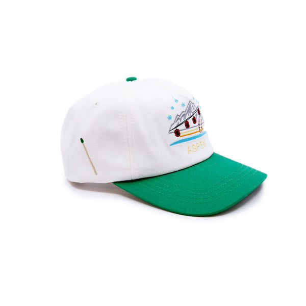 Aspen Tourist Cap  100% cotton in Cream/Green  Multicolor Embroidered 'Aspen' graphic  Yellow embroidered “Where the bluebirds sing and there’s a whiskey spring” message on side  Embroidered matchstick on reverse side  One size fits all  Made in Los Angeles 