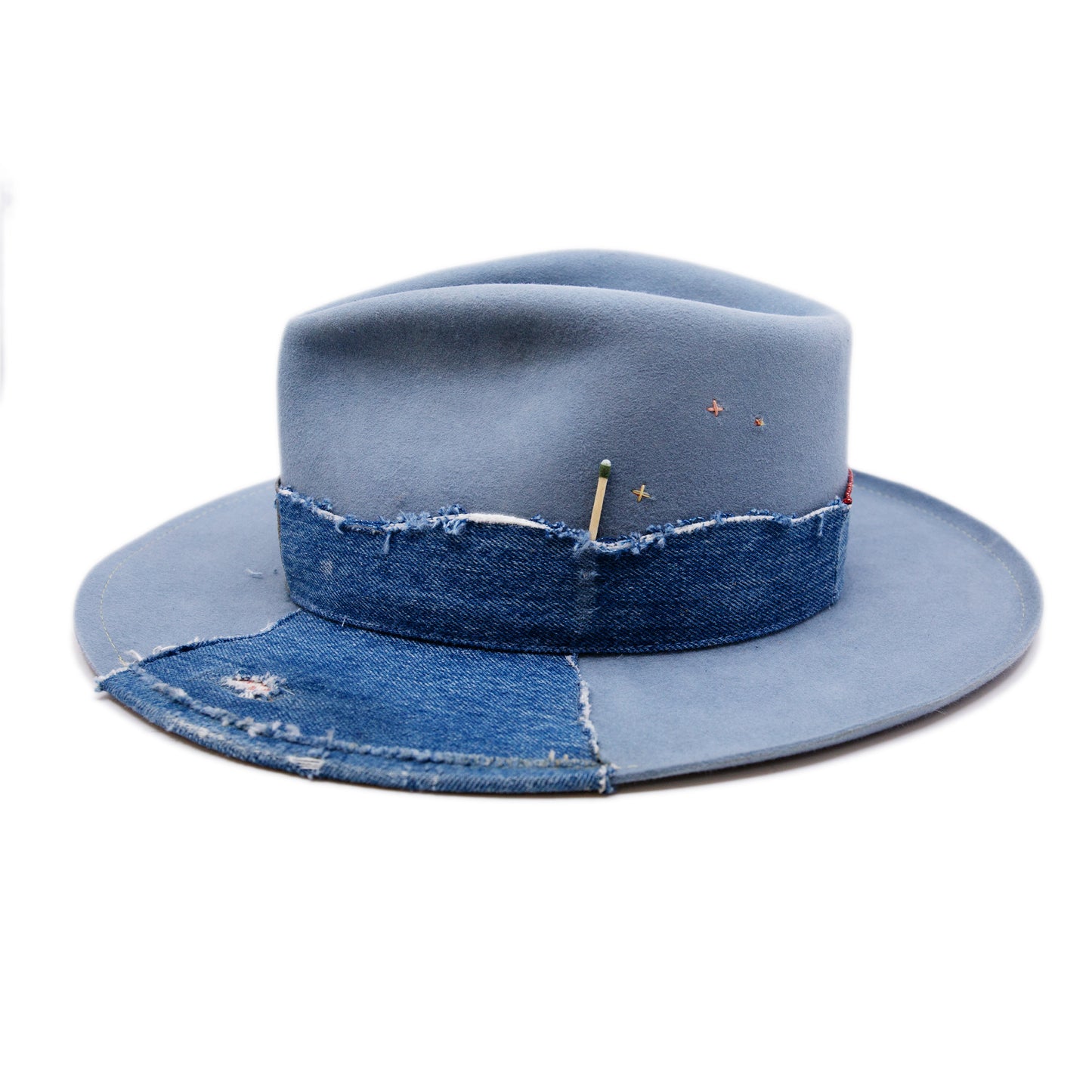 Lynn Hat  100% felt hat in Powder Blue  Dress Weight  Hand cut band from deadstock selvedge denim and calfskin leather  1/4" denim patch on brim with mending  1⁄4“ ticking on brim  Multicolor accent hand embroidery  Back pencil curled brim  Made in USA