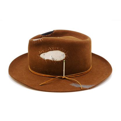 100% felt hat in Pimp Brown   Western Weight   Tonal suede lace wrapped twice   4 cut outs with two felt patches and two fabric patches  Tonal whip stitching   Wavy brim   Made in USA