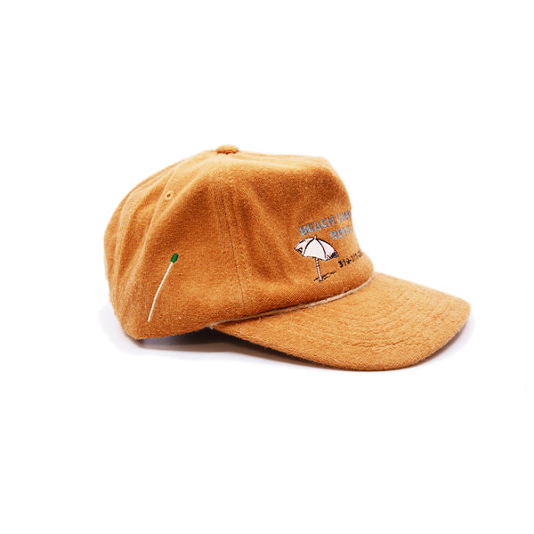 Camel terrycloth baseball cap  Natural hemp braided twine cord along brim  Beach Umbrella Rentals hotline graphic embroidered at front  Embroidered matchstick on reverse side  One size fits all  Made in Los Angeles   